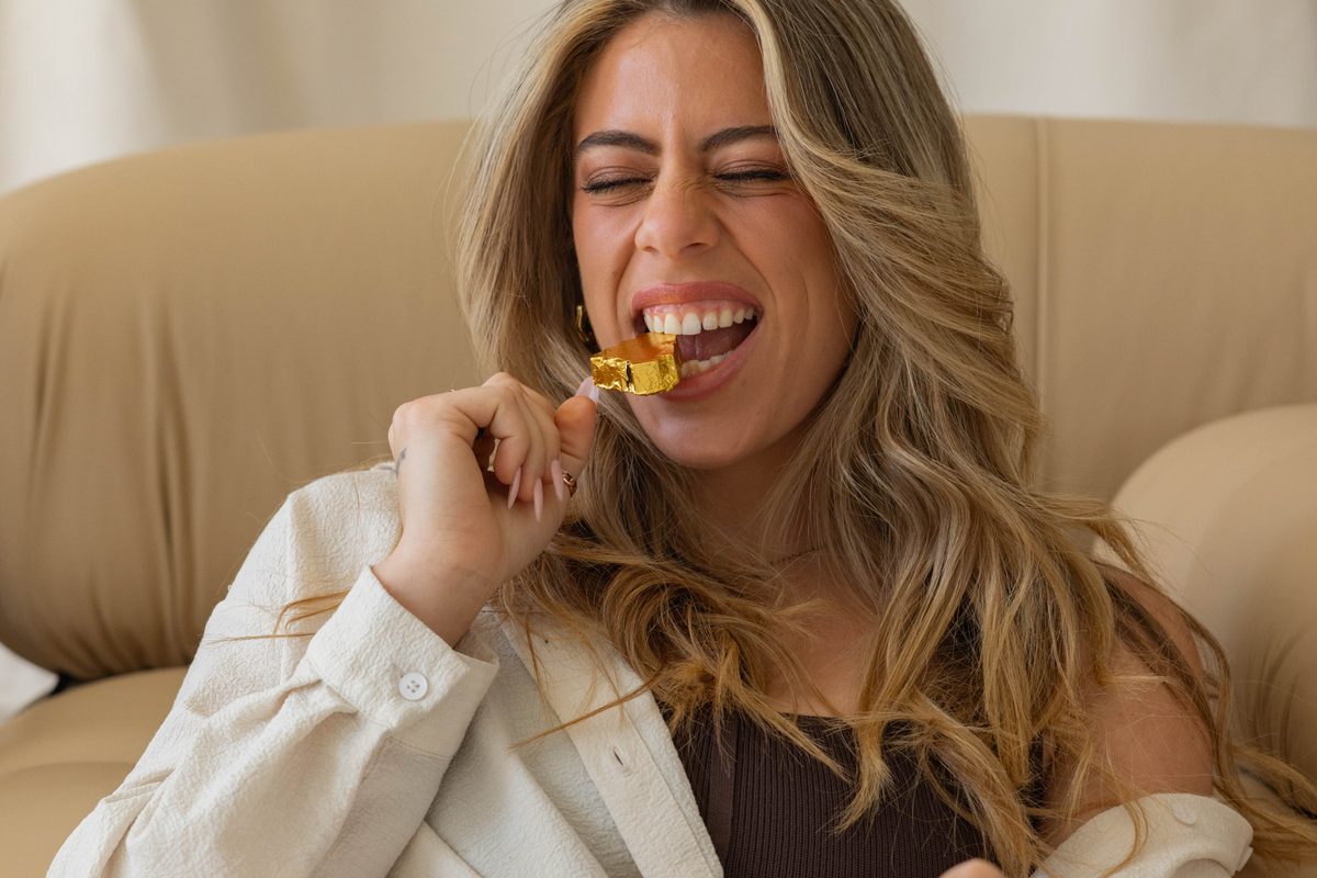 A person laughing while eating a Mycrologi chocolate heart.